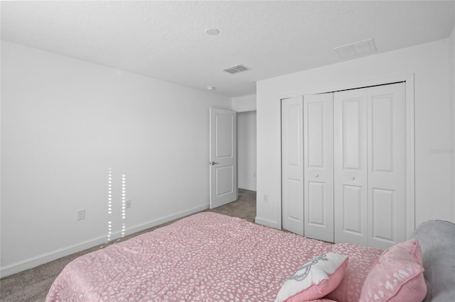 carpeted bedroom featuring a closet and a textured ceiling