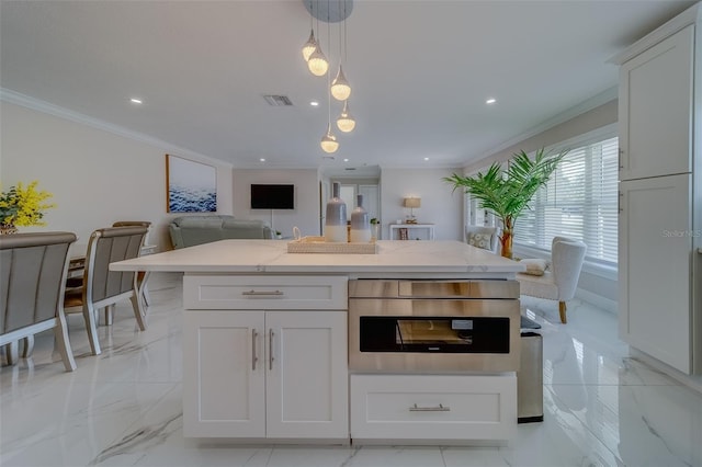 kitchen with white cabinetry, decorative light fixtures, and a center island