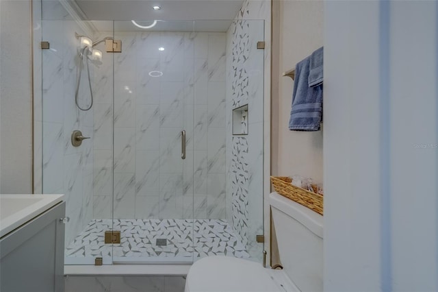 bathroom featuring toilet, vanity, and a shower with shower door