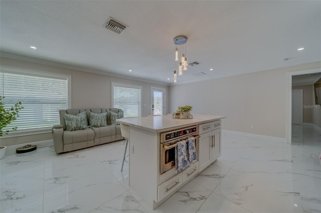 kitchen featuring decorative light fixtures, white cabinets, oven, a kitchen breakfast bar, and crown molding