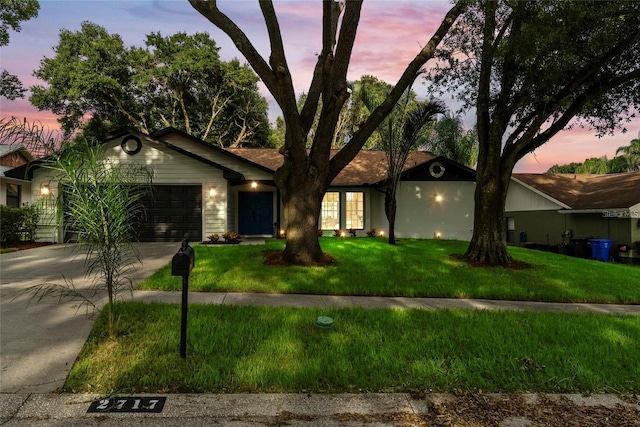 ranch-style home featuring a yard and a garage