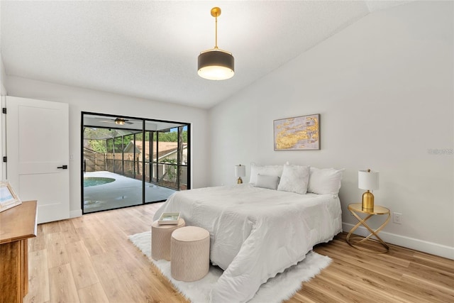 bedroom with lofted ceiling, access to exterior, a textured ceiling, and light wood-type flooring