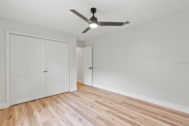 unfurnished bedroom featuring light hardwood / wood-style flooring, a closet, and ceiling fan