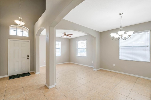 tiled entrance foyer with ceiling fan with notable chandelier