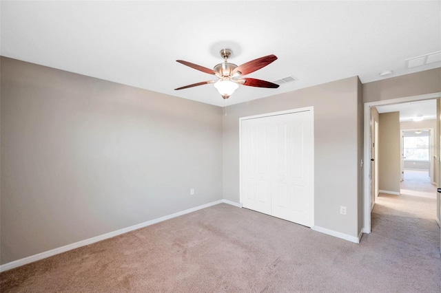 unfurnished bedroom with light carpet, ceiling fan, and a closet