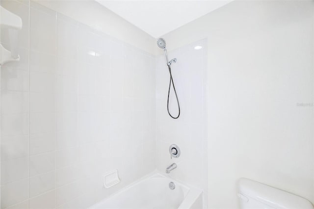 bathroom with tiled shower / bath and toilet