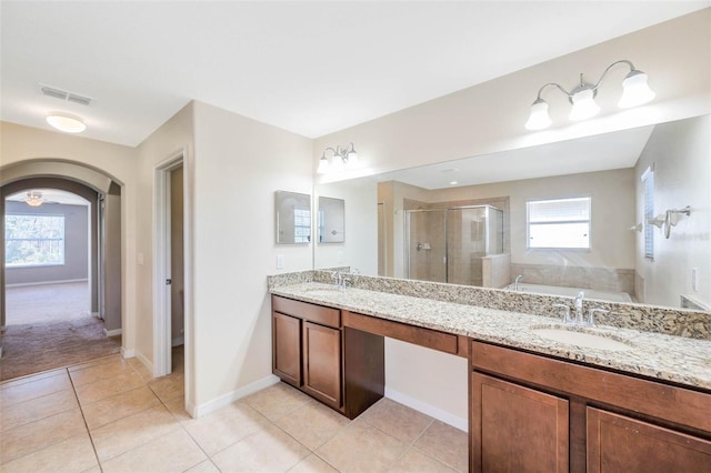 bathroom featuring a healthy amount of sunlight, independent shower and bath, tile patterned flooring, and vanity