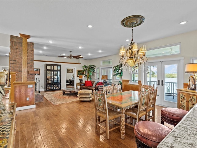 dining area with decorative columns, wood-type flooring, plenty of natural light, and french doors