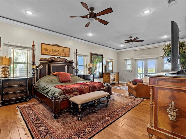 bedroom featuring multiple windows, access to exterior, crown molding, and light hardwood / wood-style floors