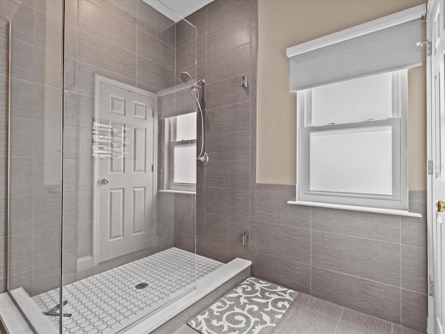 bathroom with tile walls and walk in shower