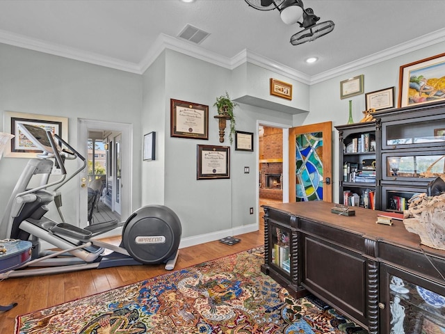 home office featuring hardwood / wood-style floors, a fireplace, and ornamental molding