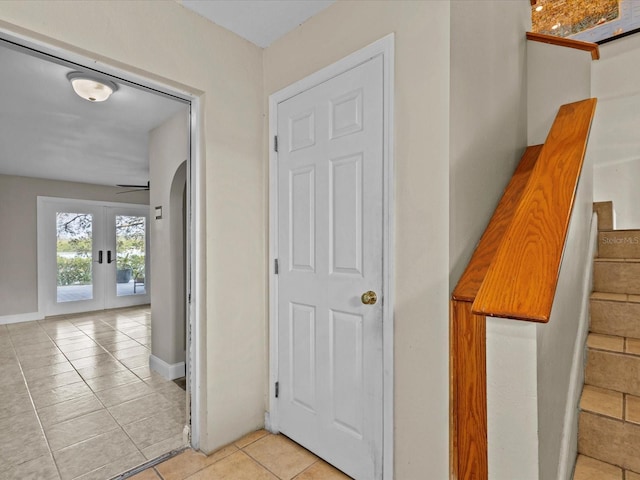 hallway with light tile patterned floors and french doors