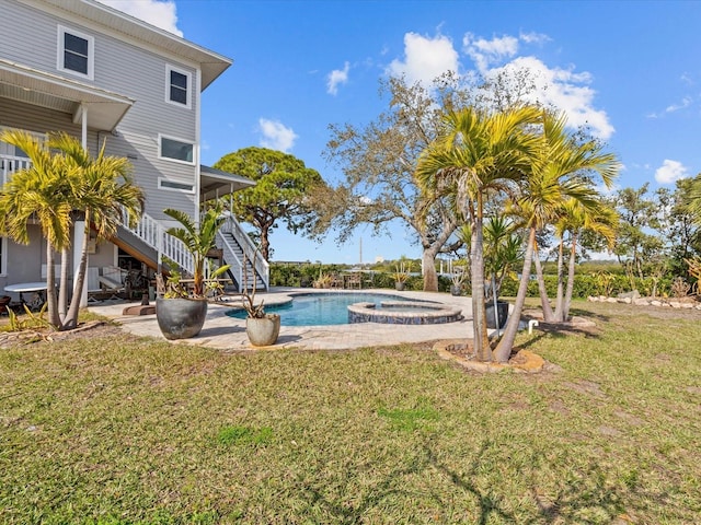 view of pool with an in ground hot tub and a lawn