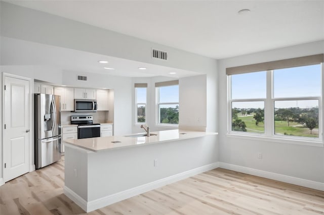 960 Starkey Rd Unit 10301, Largo, FL 33771 - kitchen with light countertops, visible vents, appliances with stainless steel finishes, white cabinets, and a peninsula