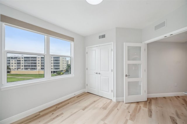 960 Starkey Rd Unit 10301, Largo, FL 33771 - unfurnished bedroom with baseboards, visible vents, and light wood finished floors