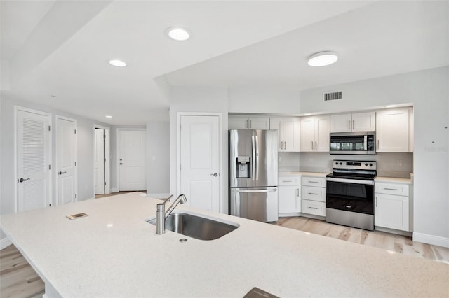 960 Starkey Rd Unit 10301, Largo, FL 33771 - kitchen featuring light wood finished floors, visible vents, stainless steel appliances, light countertops, and a sink