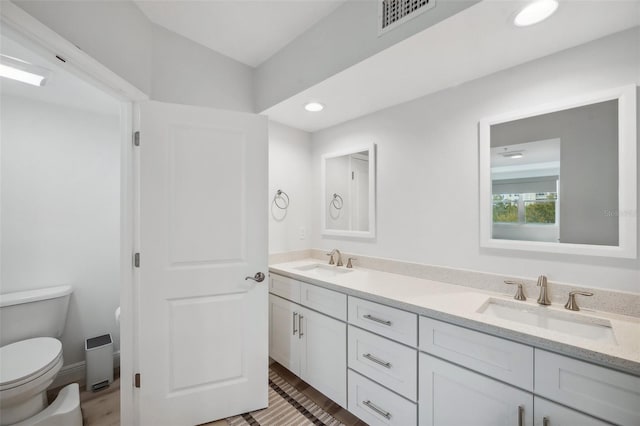 960 Starkey Rd Unit 10301, Largo, FL 33771 - bathroom with toilet, double vanity, visible vents, and a sink