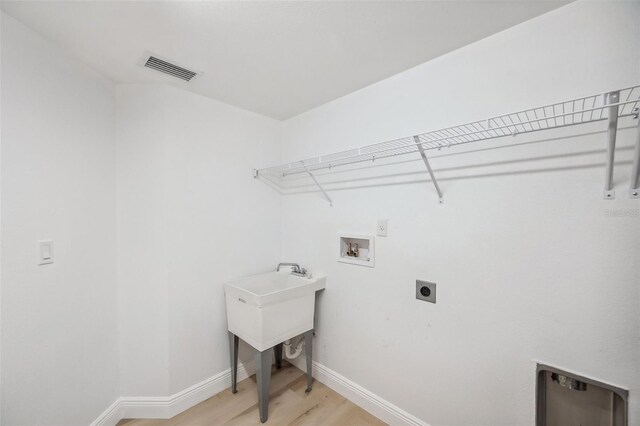960 Starkey Rd Unit 10301, Largo, FL 33771 - washroom featuring laundry area, baseboards, hookup for a washing machine, hookup for an electric dryer, and light wood-style floors