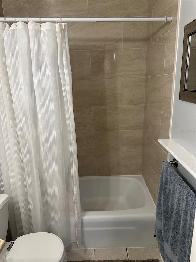 bathroom featuring shower / bathtub combination with curtain, tile patterned floors, and toilet