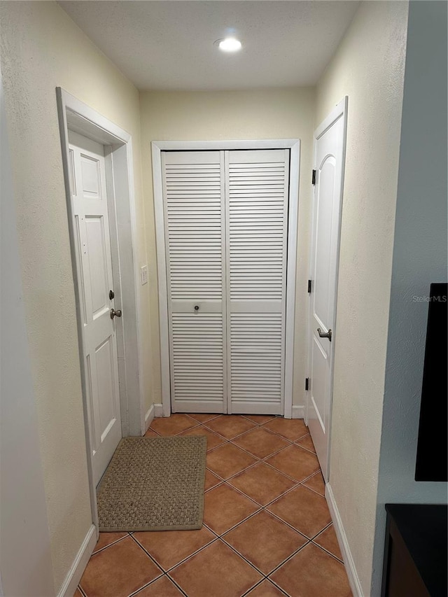 hallway with tile patterned floors