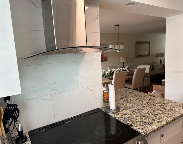 kitchen featuring pendant lighting, island range hood, stainless steel electric stove, and stone counters