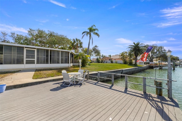 wooden deck featuring a water view, a dock, and a sunroom