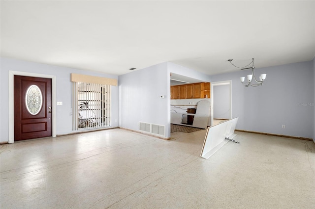 unfurnished living room with a notable chandelier