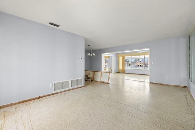 unfurnished living room featuring a chandelier