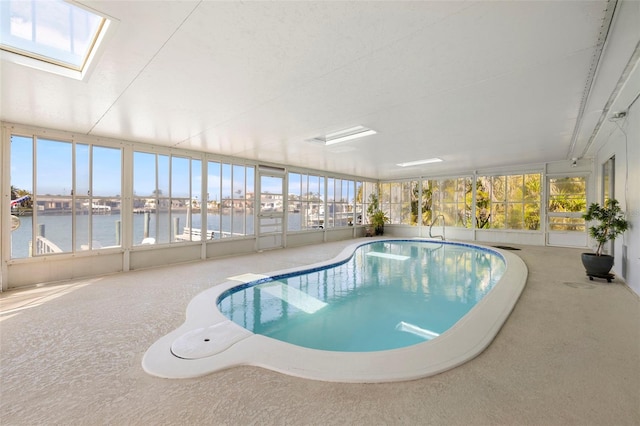 view of pool featuring a water view and a skylight