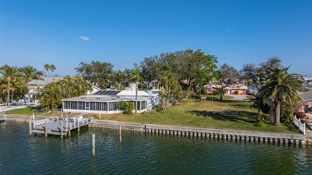 rear view of house with a water view and a yard