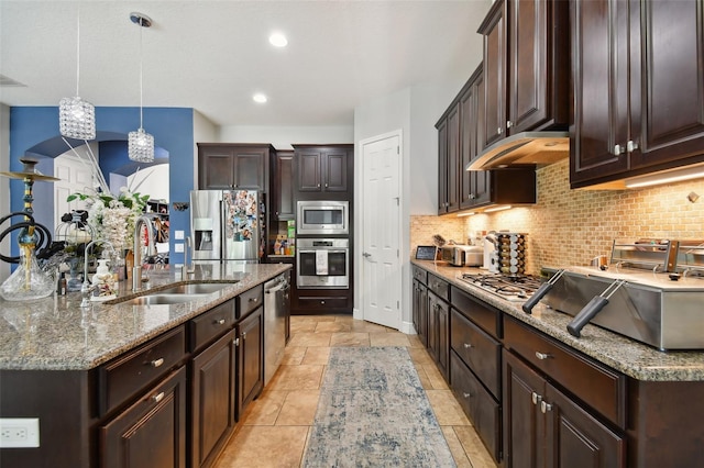 kitchen featuring appliances with stainless steel finishes, pendant lighting, sink, decorative backsplash, and dark brown cabinetry