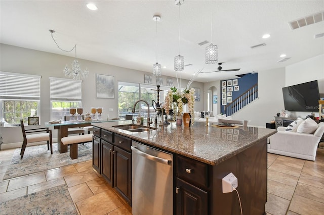 kitchen featuring decorative light fixtures, dishwasher, sink, and a center island with sink