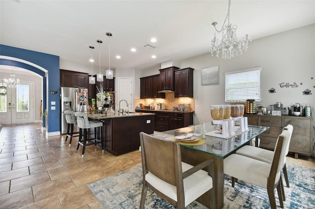 dining room featuring an inviting chandelier, sink, and french doors