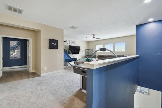 game room featuring carpet, a textured ceiling, and ceiling fan