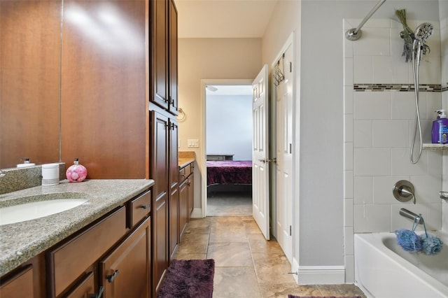 bathroom featuring tiled shower / bath and vanity