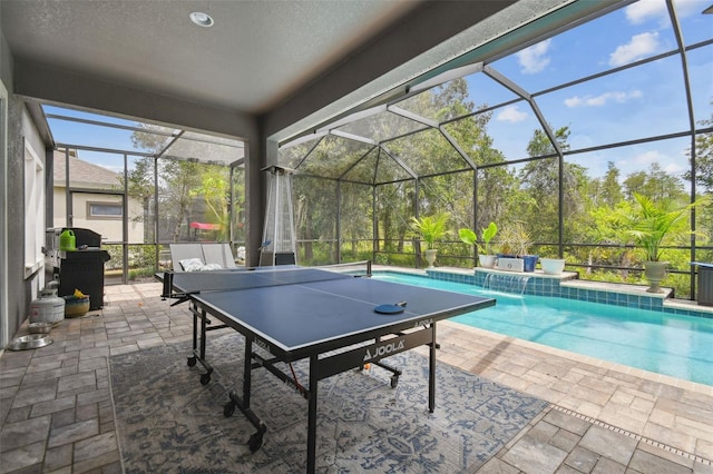 exterior space with pool water feature, a grill, and glass enclosure