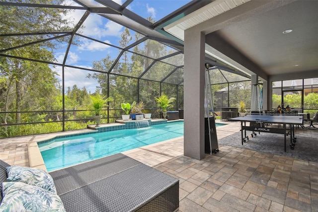 view of pool with pool water feature, a patio area, and glass enclosure