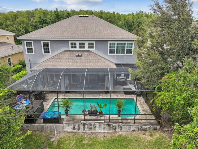 back of property with glass enclosure and a patio area