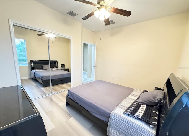 bedroom featuring light wood-type flooring, ceiling fan, and a closet