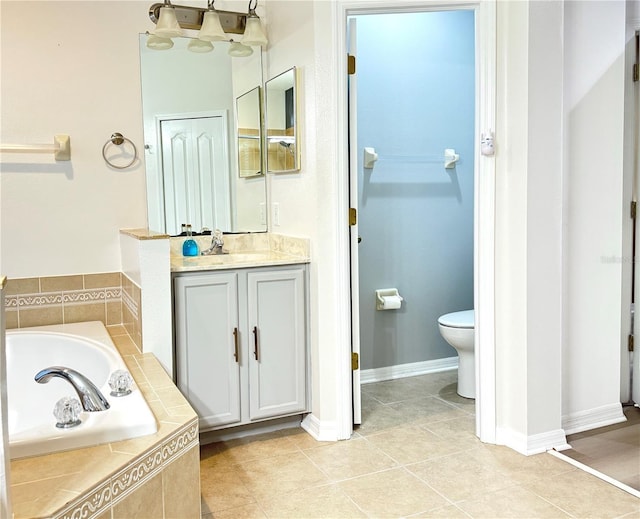 bathroom featuring a relaxing tiled tub, vanity, toilet, and tile patterned flooring