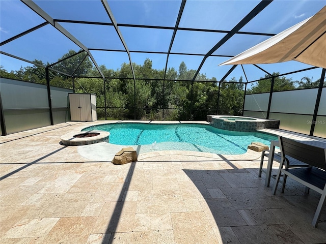 view of pool with an in ground hot tub, a fire pit, glass enclosure, and a patio