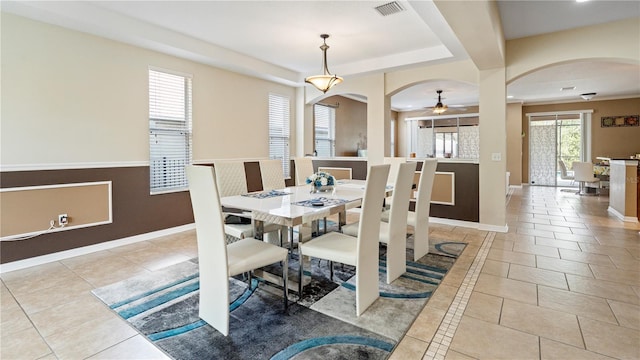 4110 Huntingdale Ct, Wesley Chapel, FL 33543 - tiled dining space with arched walkways, ceiling fan, baseboards, and a tray ceiling