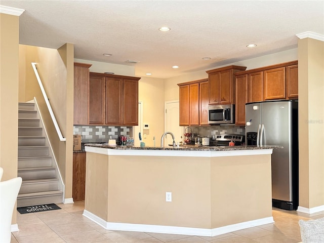 4110 Huntingdale Ct, Wesley Chapel, FL 33543 - kitchen with appliances with stainless steel finishes, brown cabinetry, backsplash, dark stone countertops, and recessed lighting