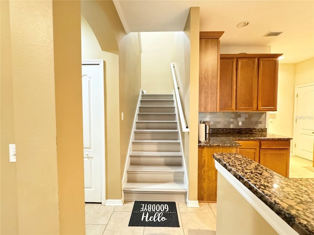4110 Huntingdale Ct, Wesley Chapel, FL 33543 - stairs with tile patterned floors, arched walkways, and baseboards