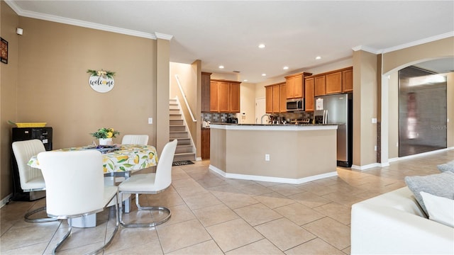 4110 Huntingdale Ct, Wesley Chapel, FL 33543 - kitchen featuring stainless steel appliances, arched walkways, crown molding, recessed lighting, and brown cabinetry