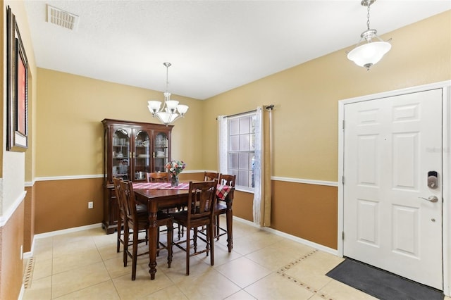 tiled dining room featuring a chandelier