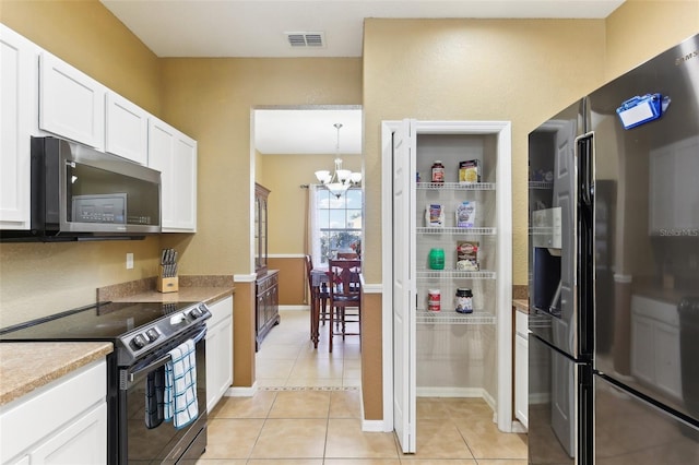 kitchen featuring light tile patterned flooring, hanging light fixtures, a notable chandelier, stainless steel appliances, and white cabinets