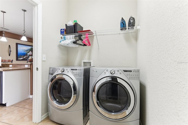 laundry area featuring washing machine and dryer and light tile patterned floors