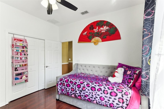 bedroom with a closet, dark hardwood / wood-style floors, and ceiling fan