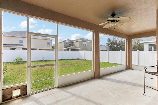 unfurnished sunroom featuring ceiling fan